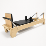 Bodylumina Premium Gold drveni pilates reformer s bež tapeciranom kliznom platformom, podesivim trakama, naslonima za ramena i footbar osloncem, profesionalna pilates sprava za reformer trening, istezanje, jačanje core mišića, stabilnost i oblikovanje tijela kod kuće ili u studiju.